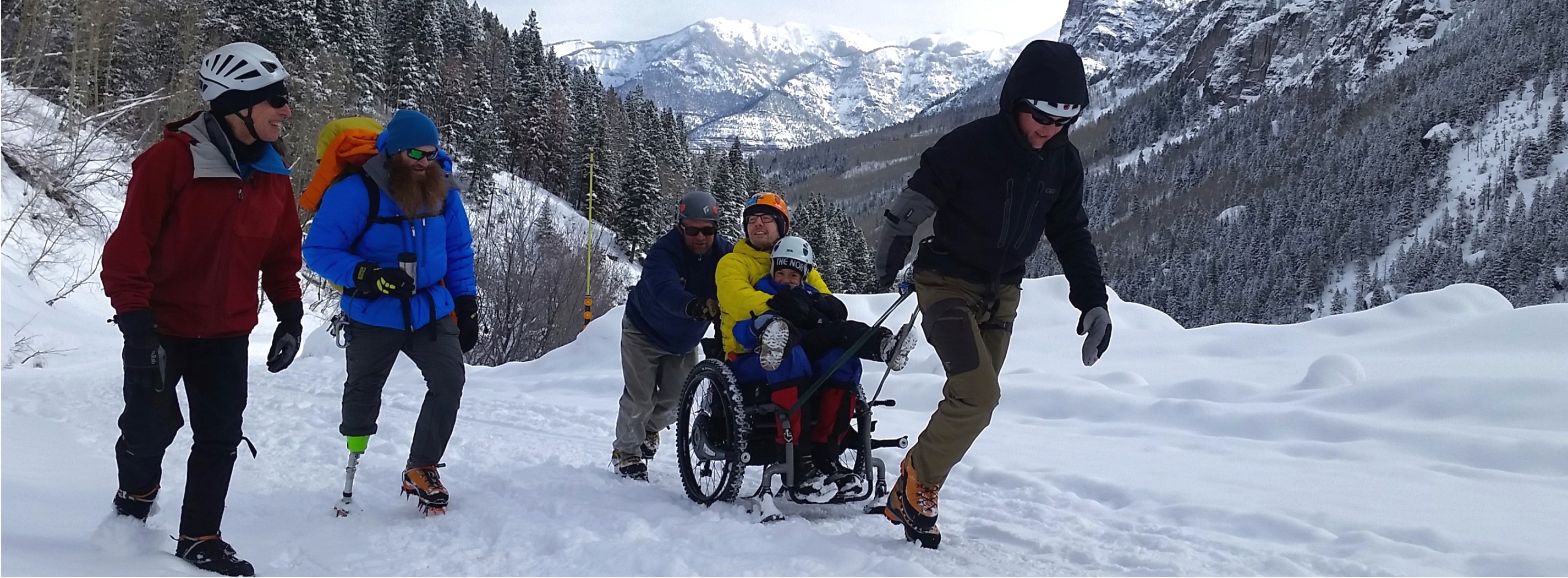 Volunteers helping paralyzed climber to the crag on an Ouray Trip