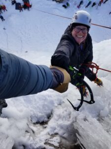 Crystan fistbumping Sam at the top of an ice route in Ouray, CO.